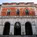 ...il livello superiore invece si presenta scandito da finestrelle rettangolari e coronato da un parapetto dentellato